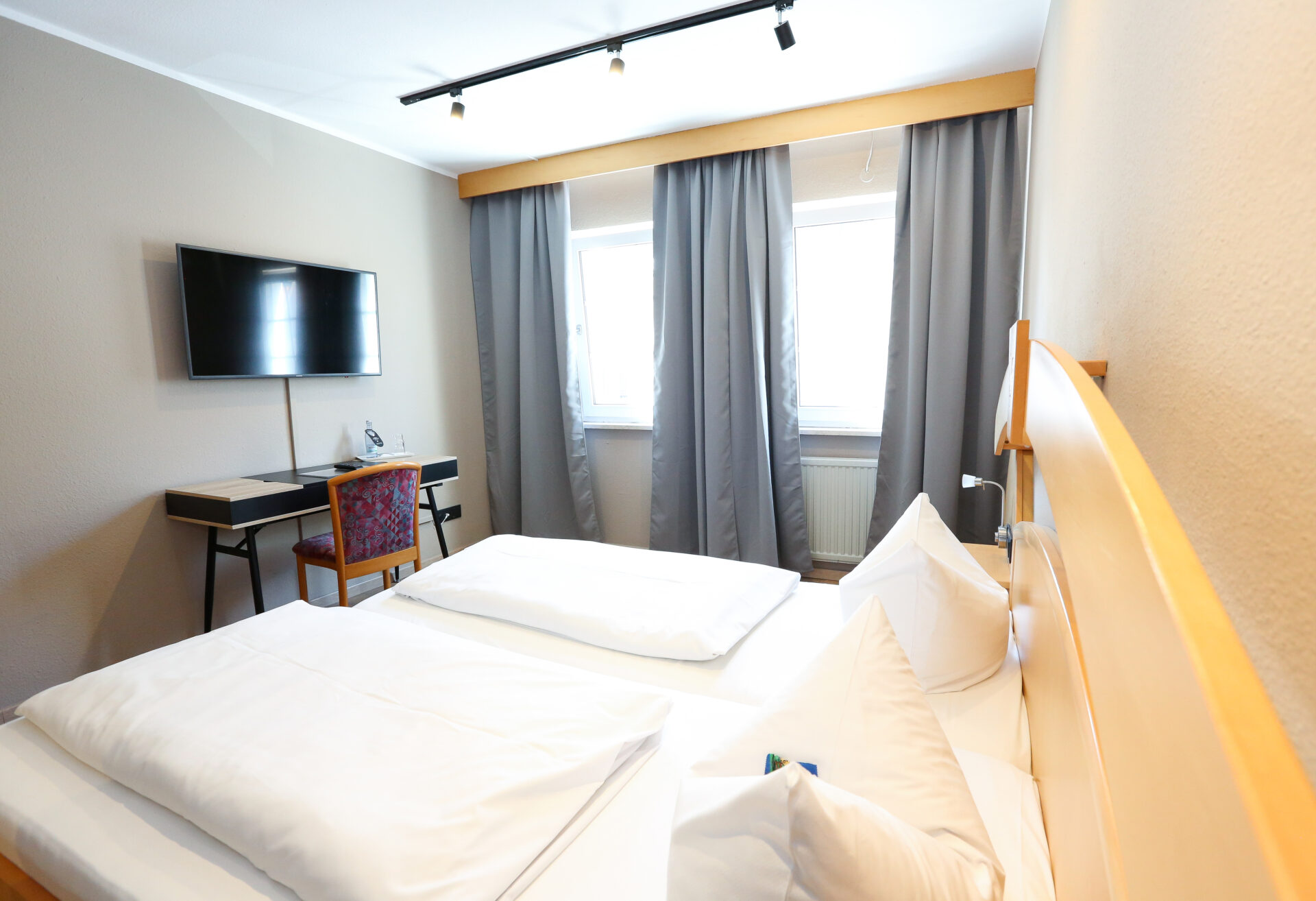 Ein Zimmer mit Arbeitsplatz und Bett im Arthotel ANA Goggl Landsberg