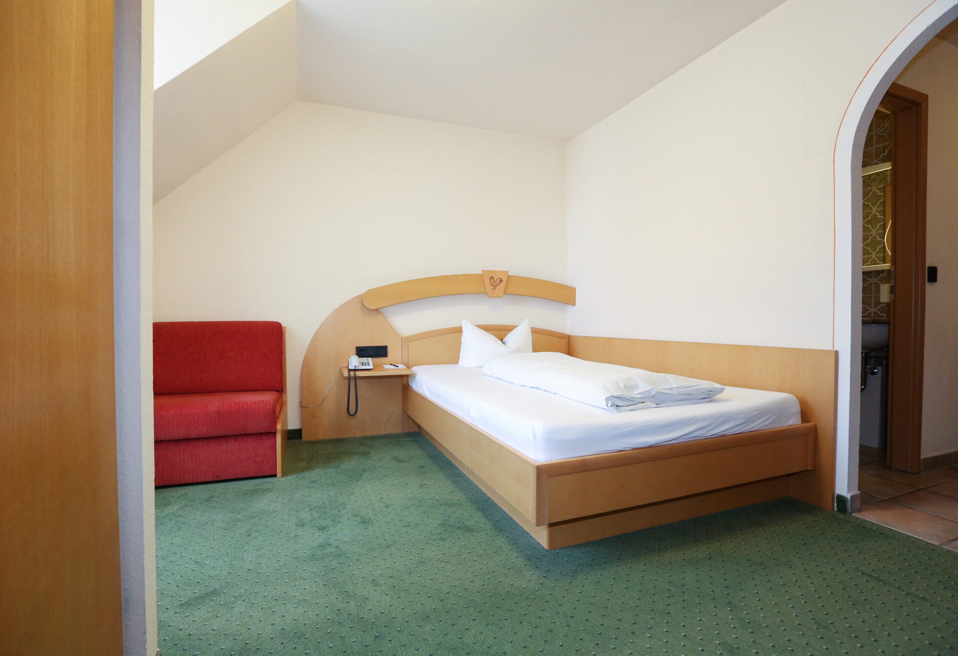 Der Schlafbereich und einer Couch im Zimmer im Arthotel ANA Goggl Landsberg