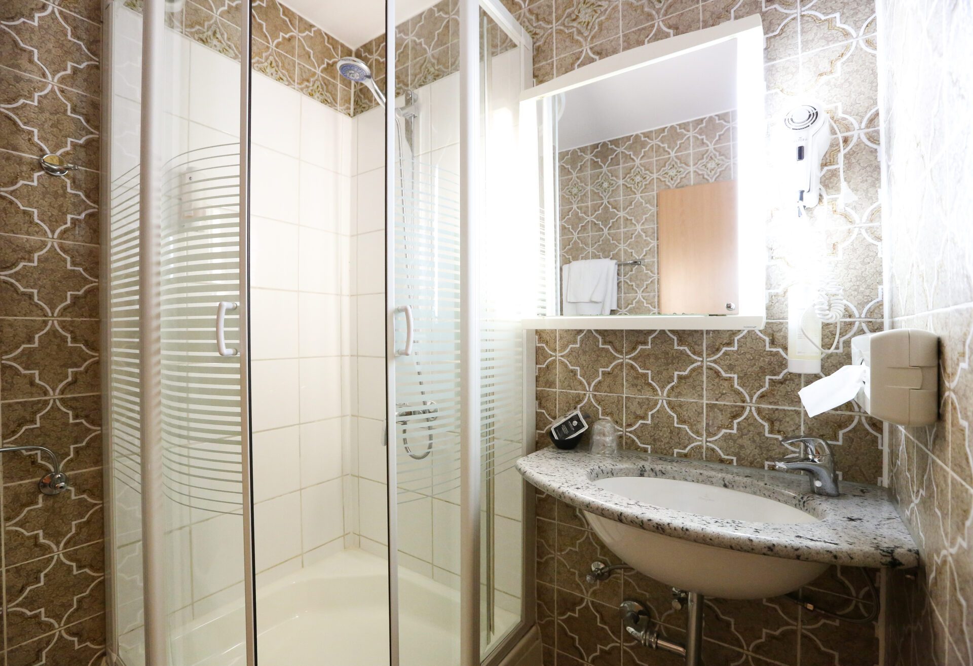 Das Waschbecken und die Dusche eines Zimmers im Arthotel ANA Goggl Landsberg