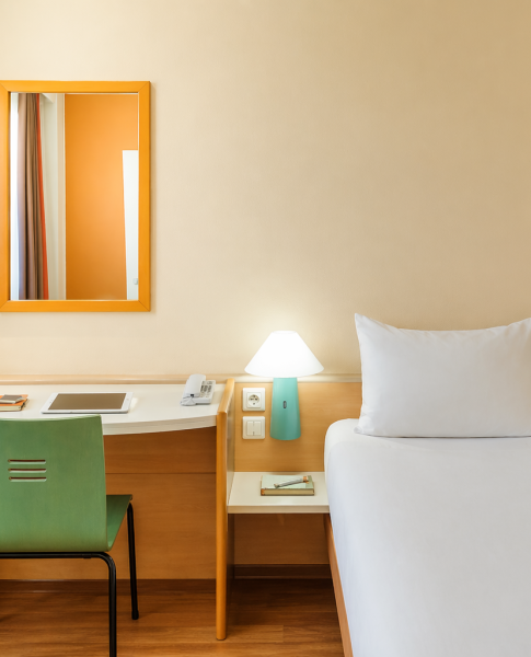 Ein Zimmer mit Schreibtisch im Ibis Augsburg Hauptbahnhof